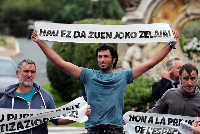 Basque activists of "No G7" hold banners reading 'This is not your playground' as they block the entry of Palace Hotel in Biarritz, southwestern France, Thursday Aug.15, 2019. The G7 will take place in Biarritz on Aug. 24-26, 2019. (AP Photo/Bob Edme)