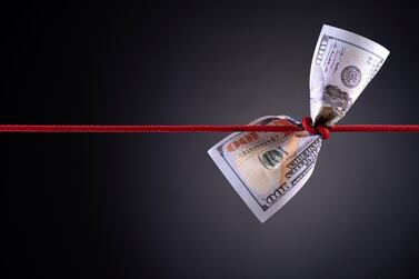 American dollar tied up in red rope knot on dark background with copy space. business finances, savings and bankruptcy concept.