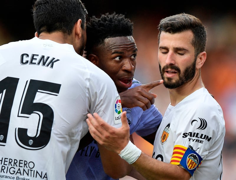 Real Madrid's Vinicius Junior gestures towards a fan after claiming he was the victim of racial abuse as Valencia's Jose Gaya and Cenk Ozkacar attempt to restrain him. Reuters