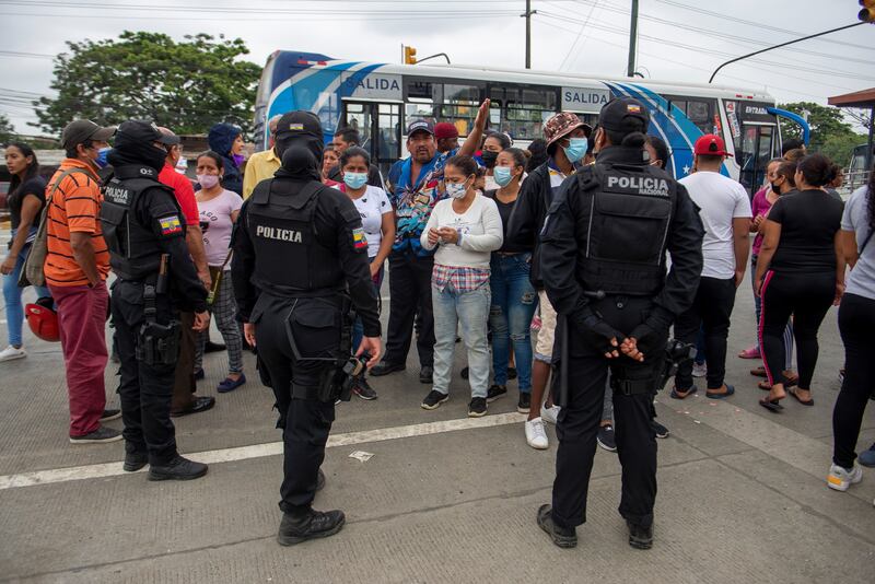 Police watch as relatives of prisoners await information about their loved ones, outside the Guayaquil prison, in Ecuador. Photo: EPA