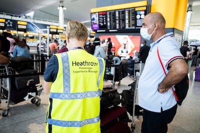 A Heathrow worker speaks to a passenger in the departure hall of Terminal 2. Mark Chilvers for The National