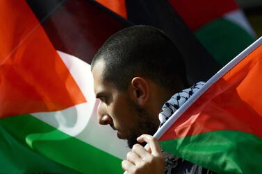 A demonstrator holds a Palestinian flag during a protest in support of the Palestinian cause. AFP