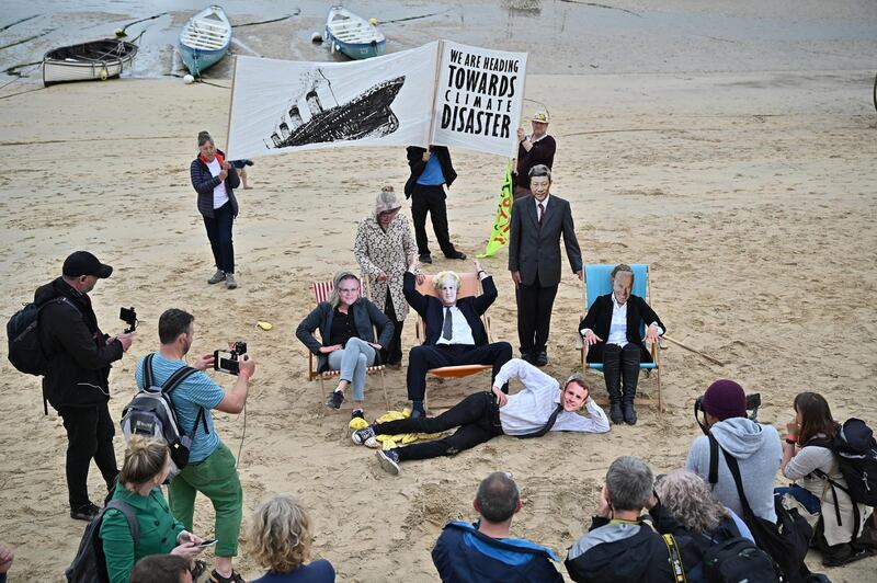 Extinction Rebellion protesters stage a "Stop Rearranging the Deckchairs" Titanic theatrical beach action in St Ives. Getty Images