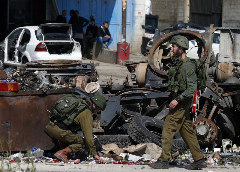 Israeli soldiers inspect the site where a Palestinian man was killed after he reported tried to stab an Israeli driver at a junction south of Nablus in the occupied West Bank.  AFP