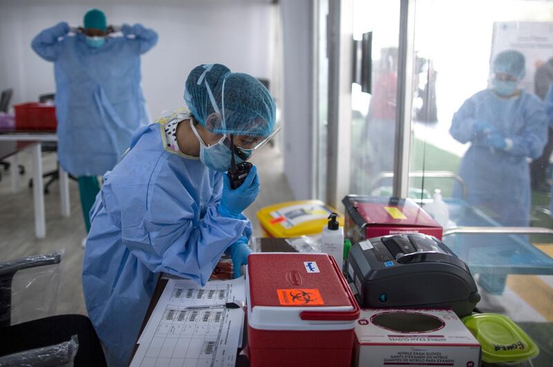 epa08358805 Members of the medical team register samples of Covid19 at a drive-through testing centre in Dubai, United Arab Emirates, 12 April 2020. The United Arab Emirates set up 13 new drive-through Covid-19 testing centers capable of carrying an average of 500 tests per day in each center. The Ministry of Health in UAE said 648,195 tests of covid-19 coronavirus were conducted till 11 April 2020.  EPA/MAHMOUD KHALED  ATTENTION: This Image is part of a PHOTO SET