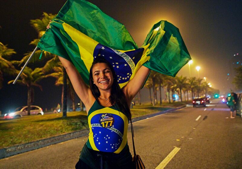 A supporter of Jair Bolsonaro celebrates outside his home in Rio de Janeiro. AFP