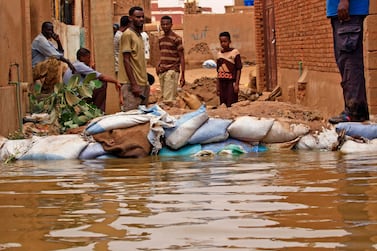 Sudanese stand amidst flood waters in Tuti island, where the Blue and White Nile merge in the Sudanese capital Khartoum, on September 3, 2020. AFP