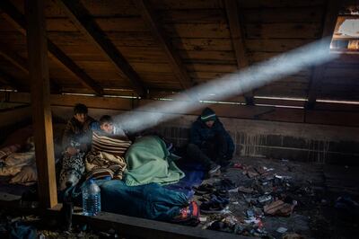 Afghan migrants wake up inside a cabin they use to sleep during their journey through the mountains of Bosnia to cross the border.