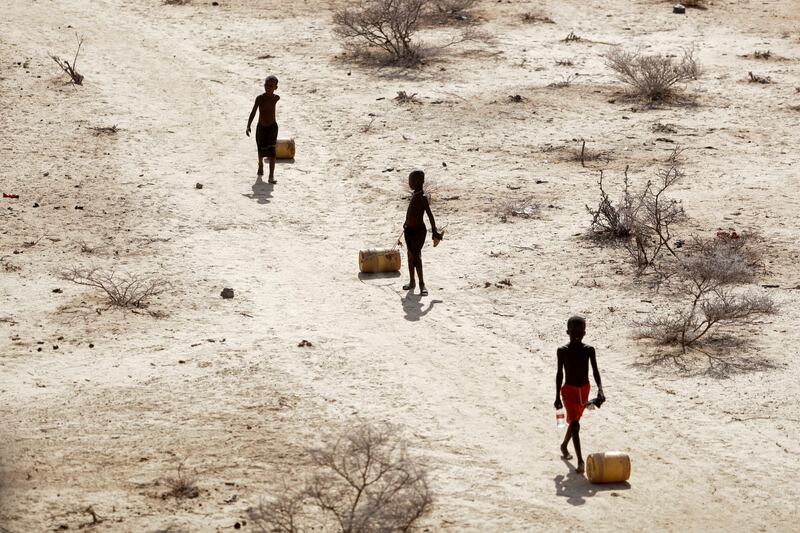 Young boys pull containers of water as they return to their huts from a well amid a drought in Kenya. AP