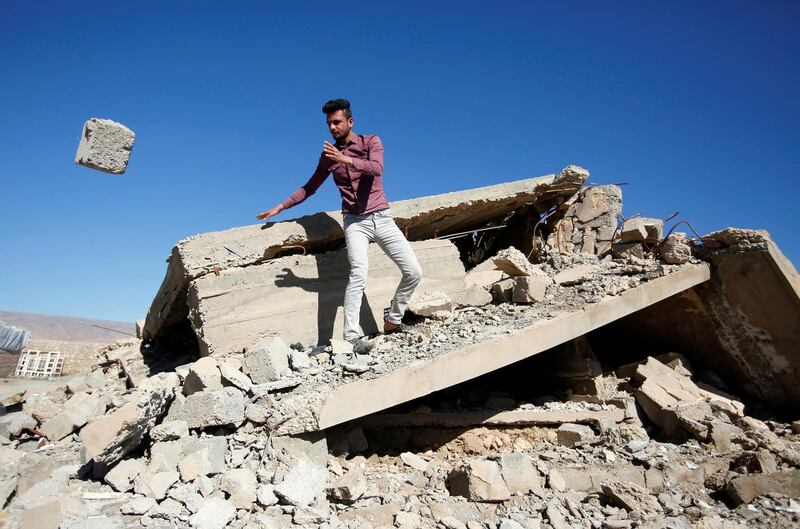 A Yazidi man raises the rubble of his damaged house near Sinjar, Iraq. Reuters