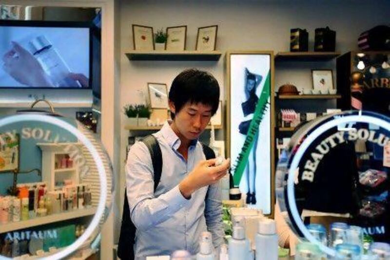 Cho Won-Hyuk, a 24-year-old student, shops for skincare and make-up products at a cosmetics store in Seoul.