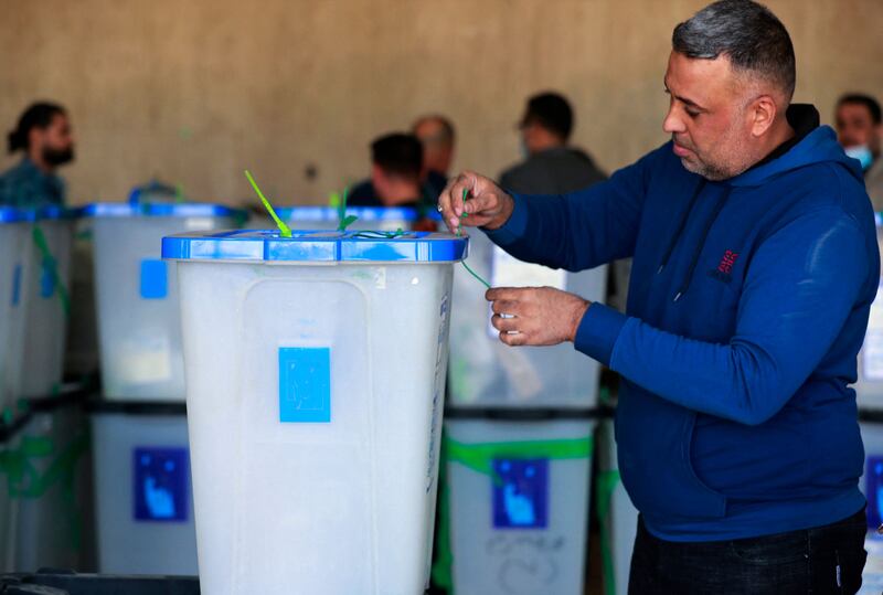 Employees of Iraq’s Independent High Electoral Commission conduct a partial manual recount in Baghdad of votes for the October 10 parliamentary elections on November 23, 2021. AFP