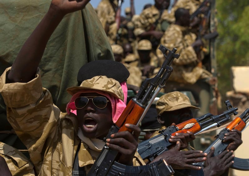 A SPLA soldier gestures as he sits in a vehicle in Juba December 21, 2013. African mediators sought on Saturday to meet rivals to South Sudan's president in a bid to end fighting that threatens to drag the world's newest country into an ethnic civil war. REUTERS/Stringer (SOUTH SUDAN - Tags: CIVIL UNREST POLITICS MILITARY)