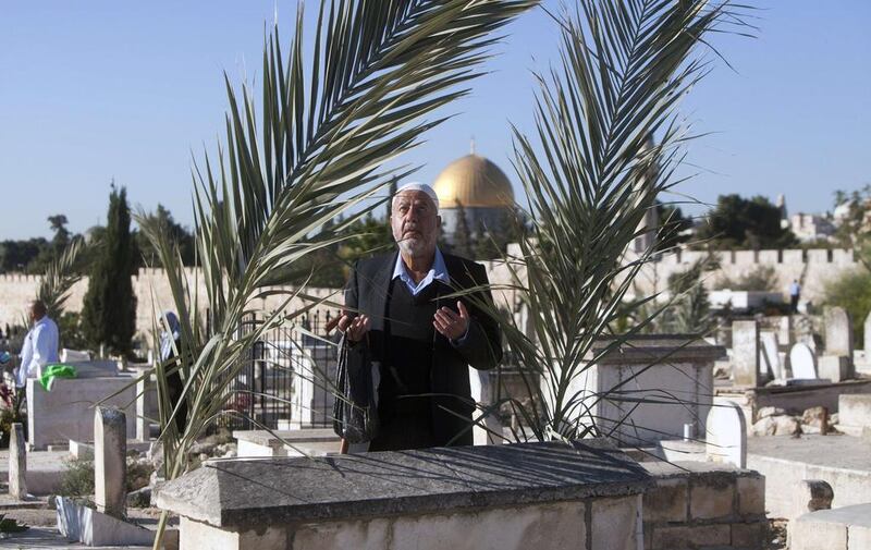 A man prays in a cemetery in Jerusalem during Eid Al Adha.