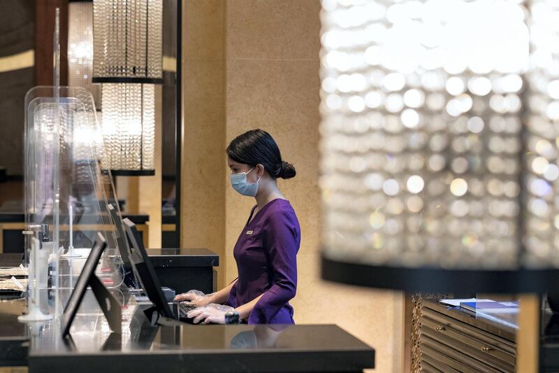 Dubai, United Arab Emirates - Reporter: N/A. Standalone. Covid-19/Coronavirus. Janel works behind a plastic partition at the H Hotel reception in Dubai. Thursday, August 27th, 2020. Dubai. Chris Whiteoak / The National