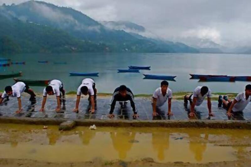 Training tough: young Nepalese men who are preparing to apply for this year's competitive Gurkha selection process do their daily push-ups by Fewa Lake, near Pokhara. Curtesy of Bibek Bhandari