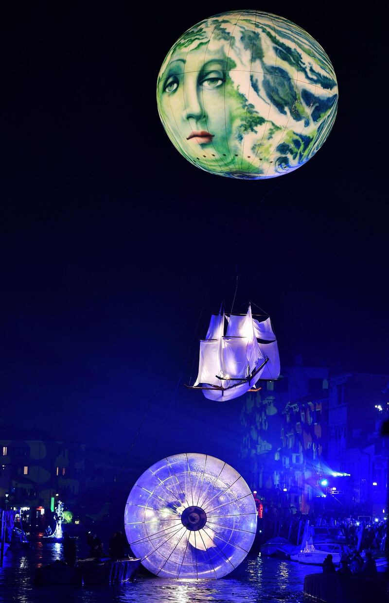 Artists perform during the 'Tutta colpa della Luna' or 'Blame the Moon' festivities down the Rio di Cannaregio, one of Venice's famed canals on February 16, 2019.  Venice began its annual Carnival festivities with a floating, night-time parade starting more than two weeks of celebrations to mark 50 years since man first walked on the moon. / AFP / Vincenzo PINTO
