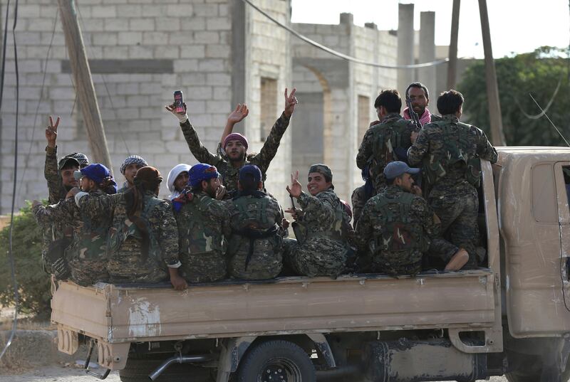 In this photo taken on Saturday, July 22, 2017, Arab and Kurdish fighters with the U.S.-backed Syrian Democratic Forces (SDF), gather on a pickup as they move to the front line to battle against the Islamic State militants, in Raqqa, northeast Syria. Kurds and Arabs are fighting side by side in the assault against the Islamic State group in Raqqa, but they have vastly different visions of what happens next. (AP Photo/Hussein Malla)