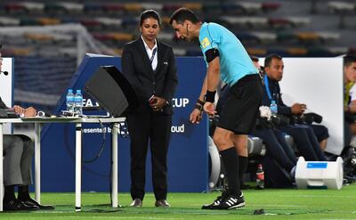 Uzbek referee Ravshan Irmatov (C) checks the video assistant referee (VAR) during the FIFA Club World Cup quarter-final match between CF Pachuca and Wydad Casablanca at Zayed Sports City Stadium in the Emirati capital Abu Dhabi on December 9, 2017. / AFP PHOTO / GIUSEPPE CACACE