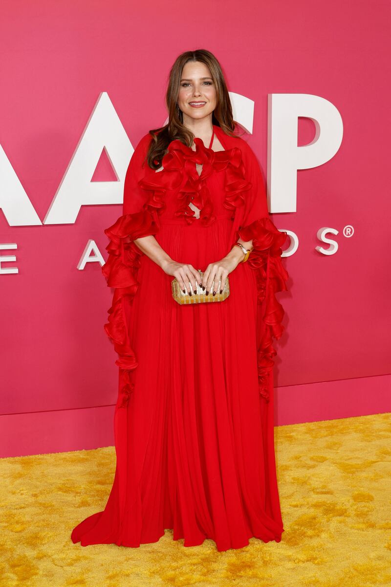 Sophia Bush wears a red caped gown. Getty Images 