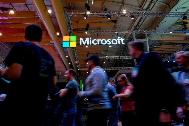 (FILES) In this file photo taken on November 6, 2019 Attendees walk past the logo of US multinational technology company Microsoft during the Web Summit in Lisbon. Microsoft said on December 30, 2019 it obtained a court order allowing it to seize web domains used by North Korean hacking groups to launch cyberattacks on human rights activists, researchers and others. The US technology giant said a federal court allowed it to take control of 50 domains operated by a group dubbed Thallium, which tricked online users by fraudulently using Microsoft brands and trademarks. / AFP / AFP  / PATRICIA DE MELO MOREIRA
