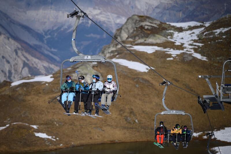 Skiers ride a ski lift before hitting the slopes during the first snows of the season above Verbier. AFP