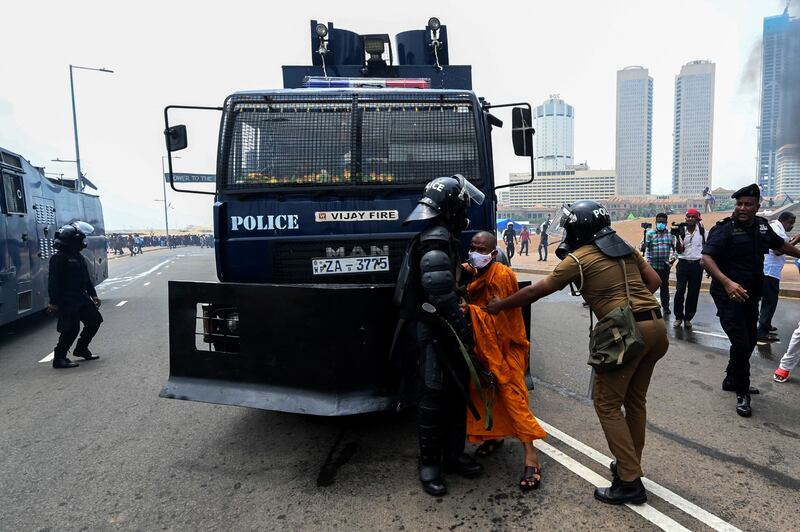 Supporters of the Sri Lankan government attempt to block a police water canon truck. AFP