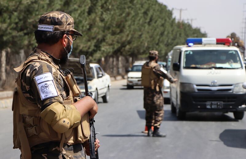 Taliban forces stand guard at a roadside checkpoint. EPA