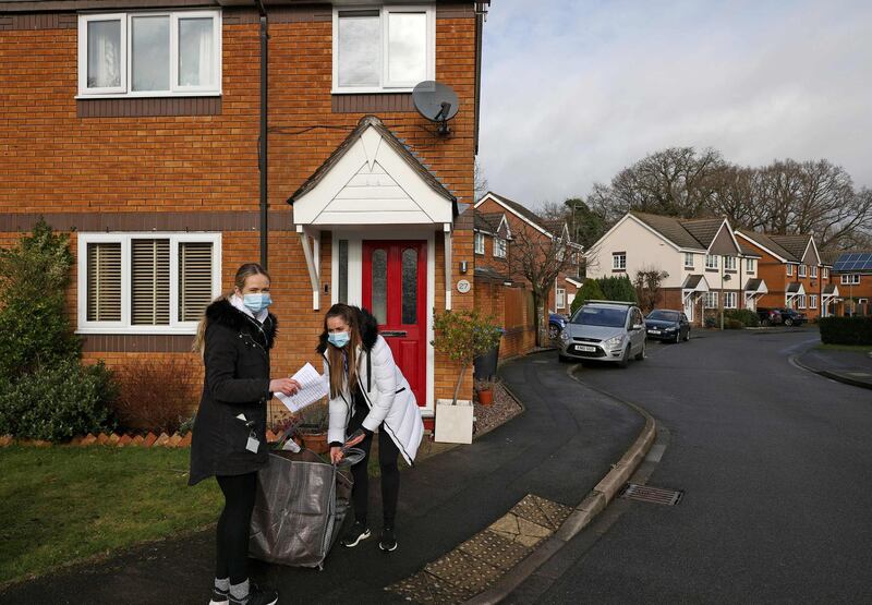 Volunteers Hanna and Sophie help to distribute coronavirus testing kits to residents in the Goldsworth Park and St John's suburbs of Woking. AFP