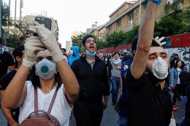 Lebanese demonstrators wear face masks as they chant slogans during a protest against the collapsing Lebanese pound currency outside Lebanon's Central Bank in Beirut. Reuters