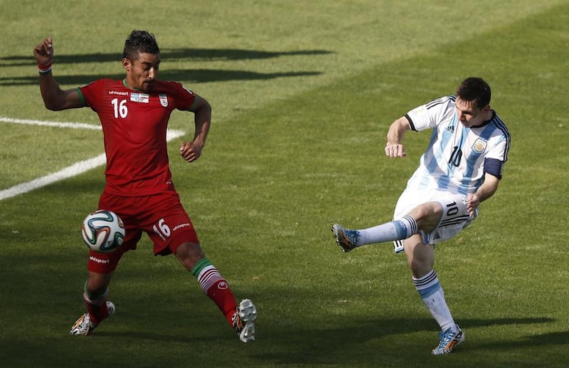 Argentina forward and captain Lionel Messi shoots past Iran forward Reza Ghoochannejhad to score the winner in the 1-0 result on Saturday at the 2014 World Cup in Belo Horizonte, Brazil. Adrian Dennis / AFP