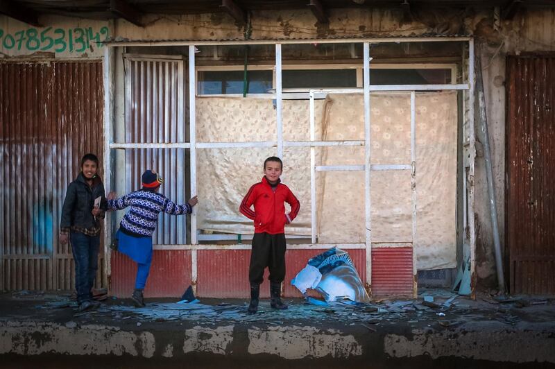 Afghan children look at the broken glass at the site of a rocket attack at a residential house in Kabul, December 12, 2020. EPA