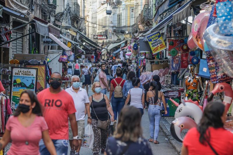 People walk through a commercial area of Rio de Janeiro, Brazil. The city, which has been hit hard by the pandemic, reopened bars, restaurants and shops on Friday, April 9, after 10 days of closures to contain coronavirus cases. EPA