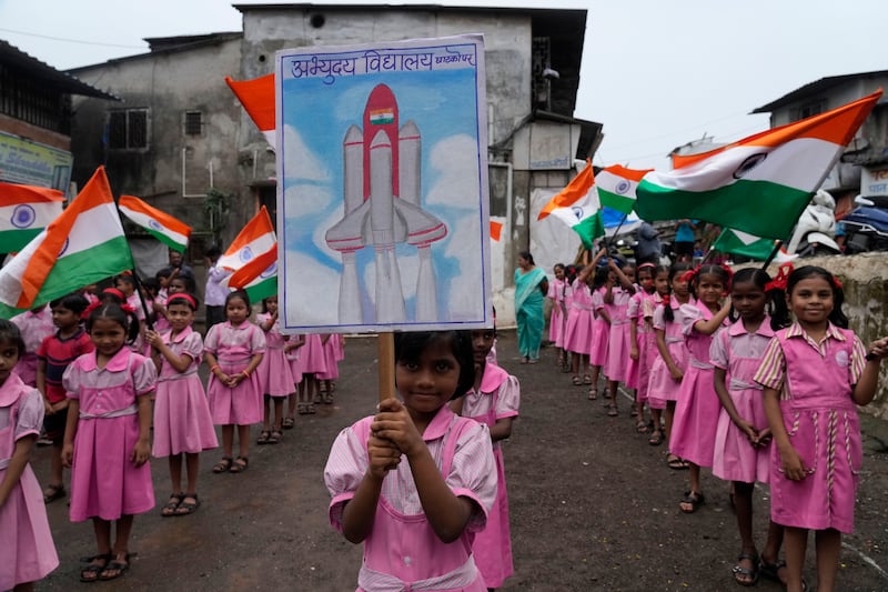 Schoolchildren wave flags and banners in Mumbai, India, as they cheer for a successful moon landing by Chandrayaan-3. AP