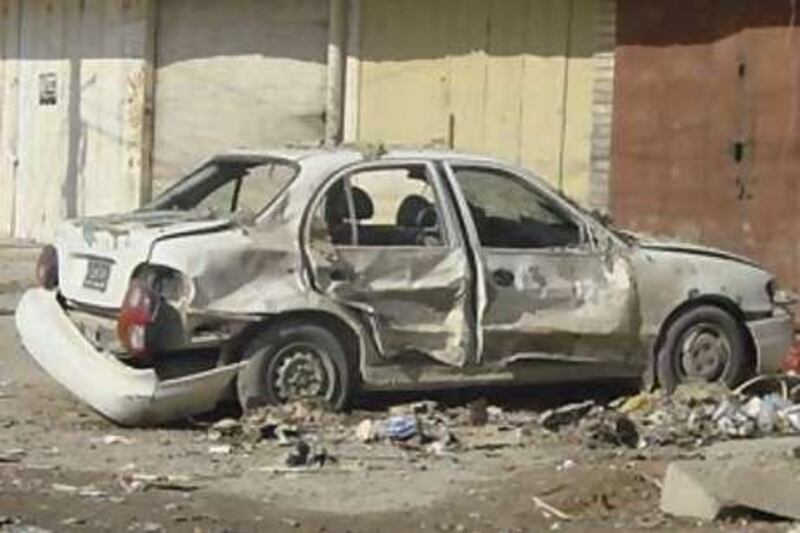 A damaged vehicle lies on a road after a bomb attack in Baghdad.