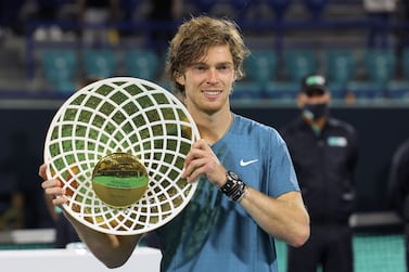 First-place winner Andrey Rublev of Russia holds up his trophy during the awards ceremony after the final match of the Mubadala World Tennis Championship in the Gulf emirate of Abu Dhabi on December 18, 2021.  (Photo by Giuseppe CACACE  /  AFP)