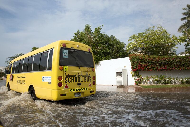 School Bus drives through a residential area in Jumeirah 1 as rain water collects on the roads. 