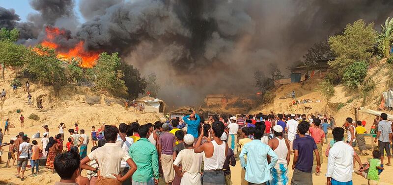 Rohingya refugees watch the smoke rising after a fire at the Rohingya refugee camp in Balukhali, southern Bangladesh. AP Photo