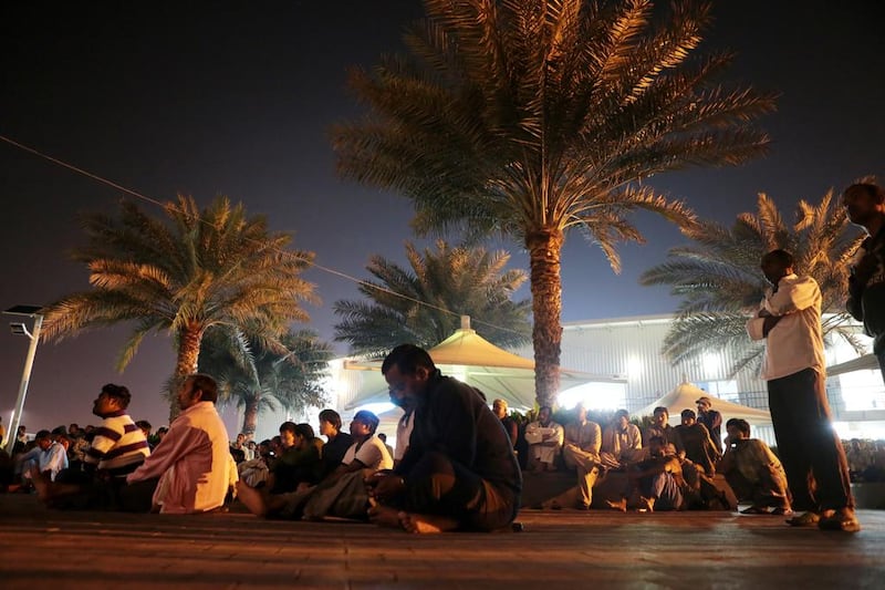 Workers watch a movie on an outdoor projector. Christopher Pike / The National