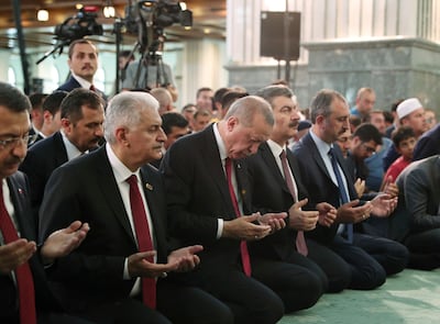 Turkey's President Recep Tayyip Erdogan, center, recites Quran during a ceremony at a mosque inside his presidential palace, in Ankara, Turkey, Sunday, July 15, 2018, as the nation is commemorating the second anniversary of thwarting a coup against the Erdogan and his government. Erdogan and top officials attended a Quran recitation in Ankara on Sunday, kicking off a series of events with prayers. (Presidential Press Service Pool via AP)