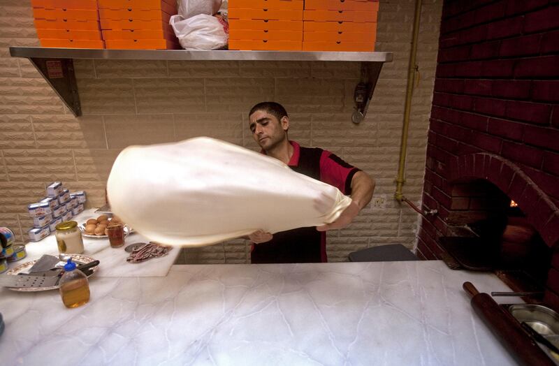 Ajman, August 8, 2011 - Hamdy Mohammad Zaki stretches the dough to make a Fatir, a flat bread pastry that is filled with meat or vegetables, at the Shabrawy Restaurant on the corniche in Ajman City, Ajman August 8, 2011. Zaki moved from Cairo as the suggestion of his cousin who lives in Dubai. (Jeff Topping/The National) 
