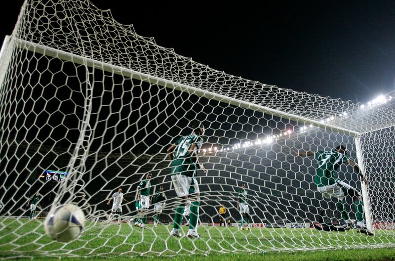 Saudi Arabia players fail to clear the ball as Iraq's Younis Mahmoud scores in the final. Reuters