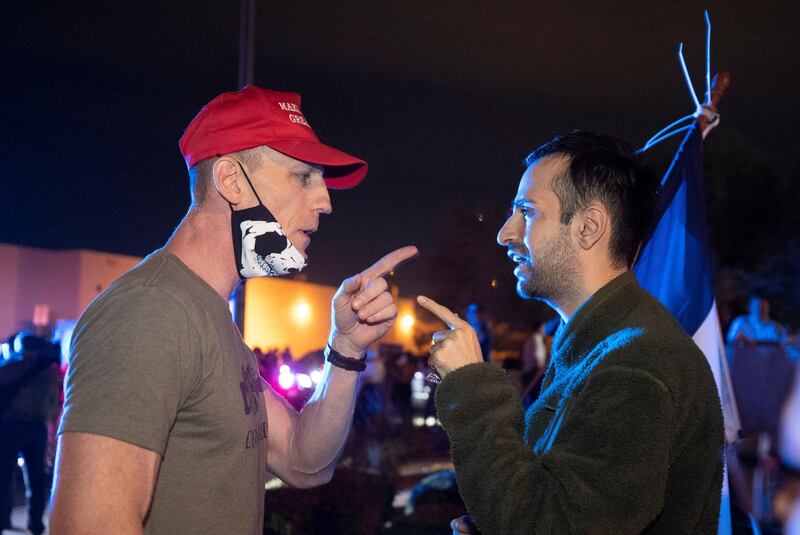 A supporter of President Donald Trump argues with a man holding a Democratic Party flag during a 'Stop the Steal' protest. Reuters