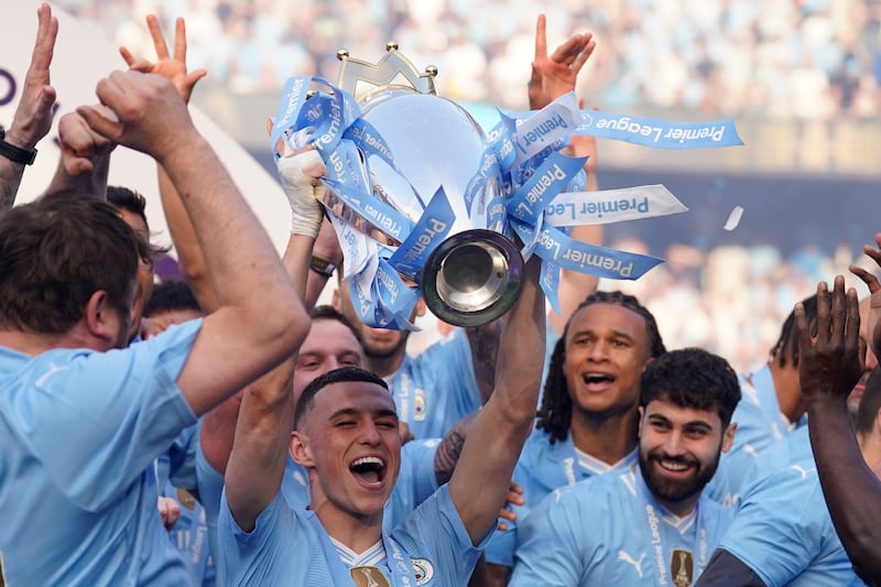 Manchester City's Phil Foden celebrates with the Premier League trophy. AP