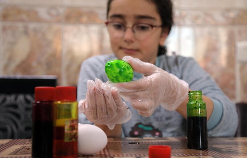 A girl decorates eggs on Holy Saturday, as Christians worldwide following the Western Gregorian calendar mark the Easter holiday weekend, in Arbil, the capital of the autonomous Kurdish region of northern Iraq.   AFP