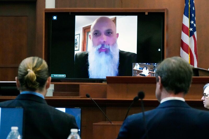 Travis McGivern, security for Johnny Depp, is seen on a monitor as he testifies remotely in the courtroom. AFP