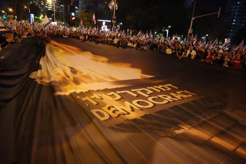 Demonstrators raise a large banner demanding 'democracy'. AFP