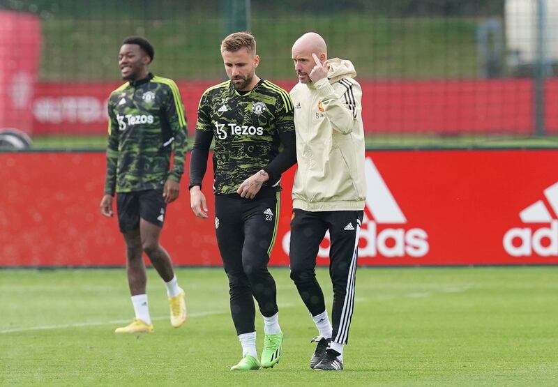 Manchester United's Luke Shaw talks with manager Erik ten Hag during training. PA