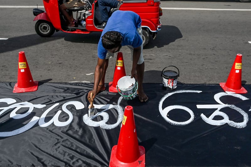 A demonstrator writes a slogan against acting president Ranil Wickremesinghe. AFP