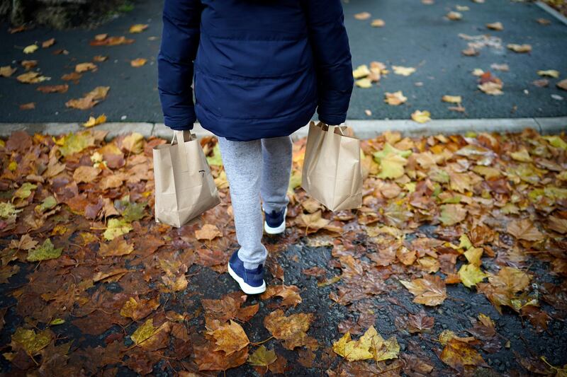 A young boy carries free half-term meal packs for himself and his sibling from the Watering Can Cafe in Liverpool. Getty Images